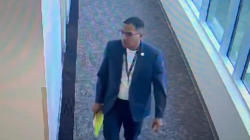 Dr. Liggins is seen slipping a paper under a doorway at the John D. Price Admin building.