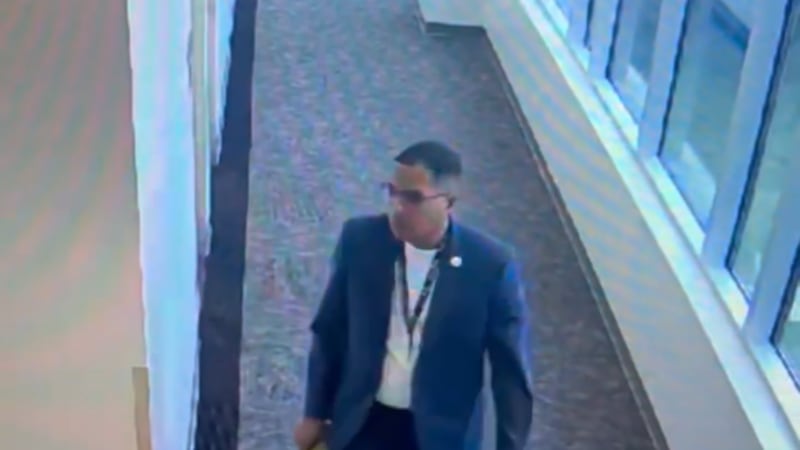 Dr. Liggins is seen slipping a paper under a doorway at the John D. Price Admin building.