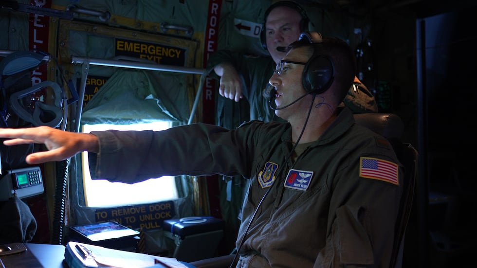 Second Lt. Andrew Wilson discussing data with a Hurricane Hunters crew member.