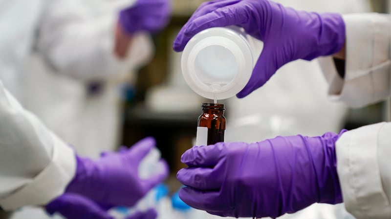 FILE - Eva Stebel, a water researcher, pours a water sample into a smaller glass container for...