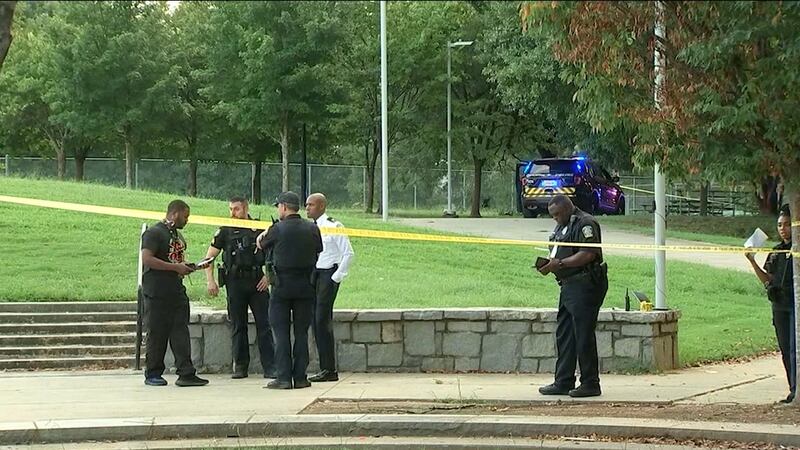Police are seen investigating after a shooting at Atlanta's Dunbar Park on Sunday.